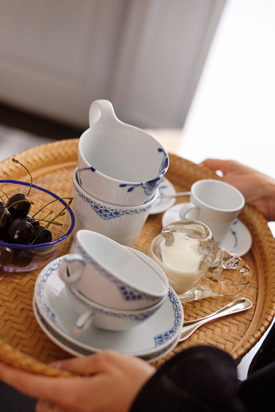 A tray with Princess tea cups and a Princess high handle cup, a glass milk jug and a glass bowl with cherries.