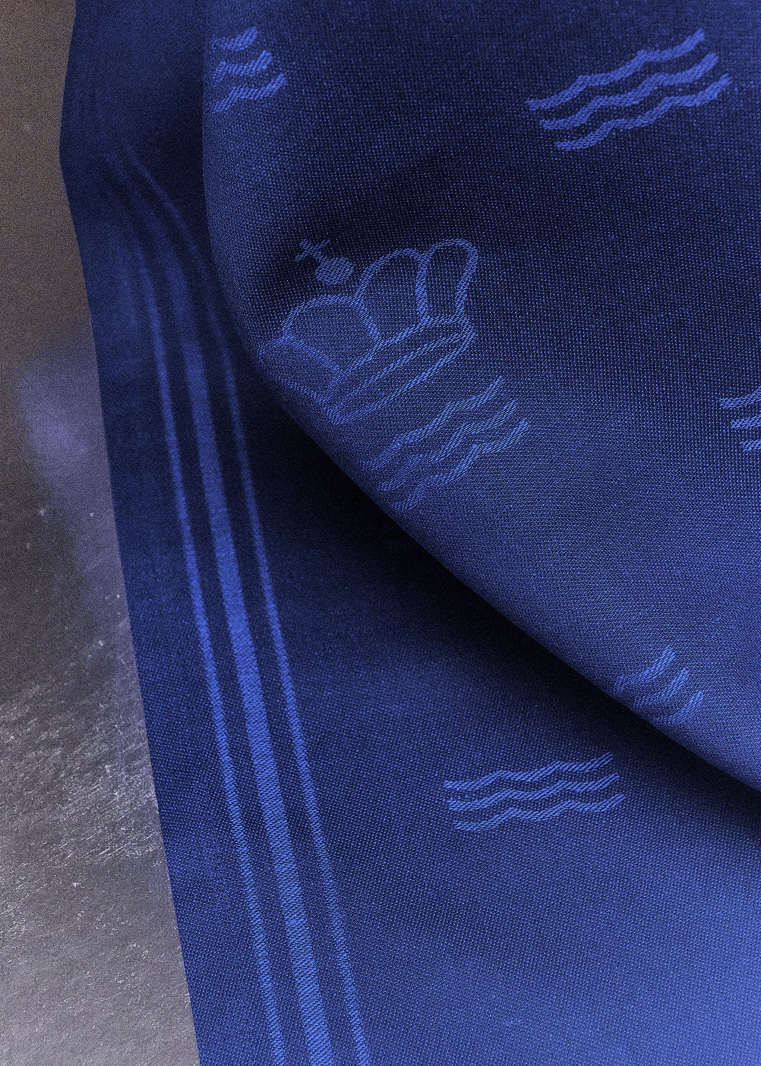 Close-up of blue Waves tablecloth showing both the crown and the waves representing Royal Copenhagen.