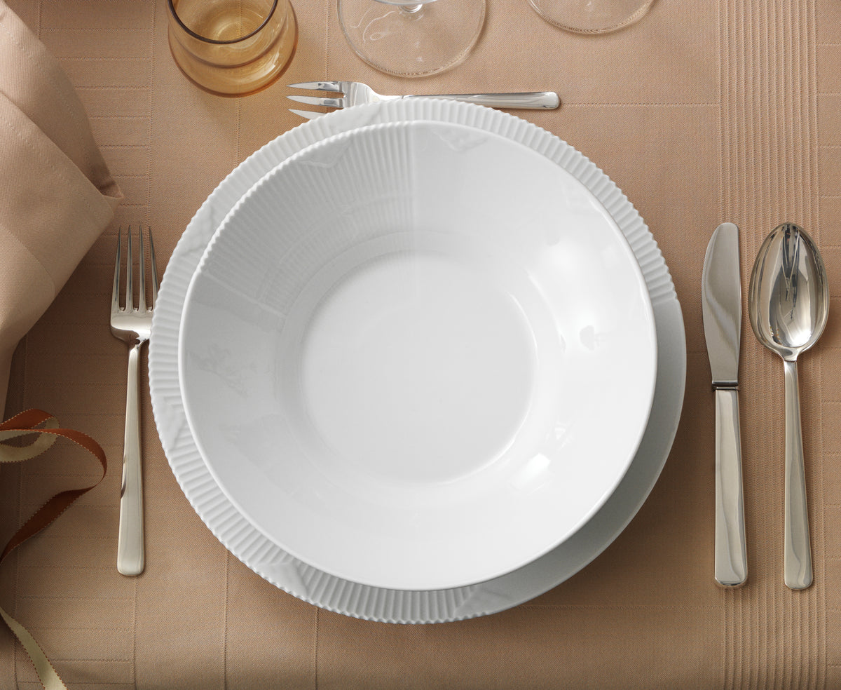 White Elements plate with silverware on a beige tablecloth